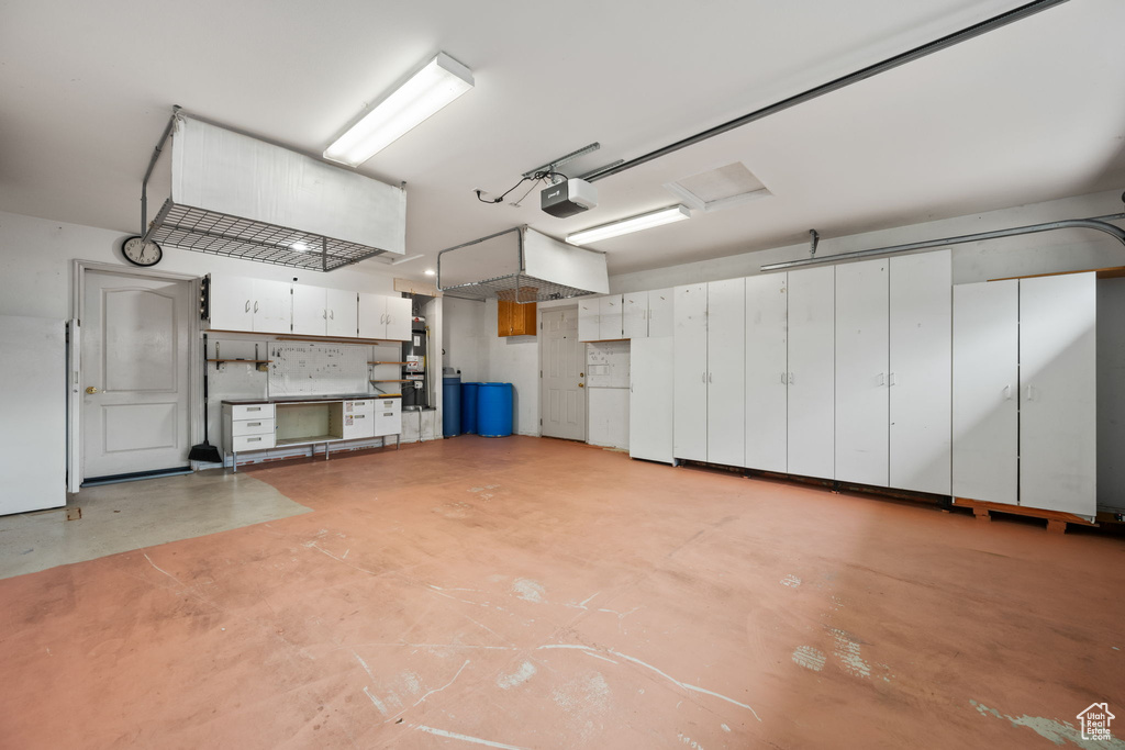 Garage with a garage door opener and freestanding refrigerator