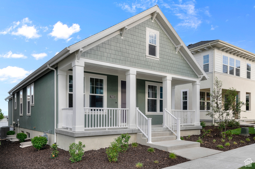 View of front facade with covered porch and central AC unit