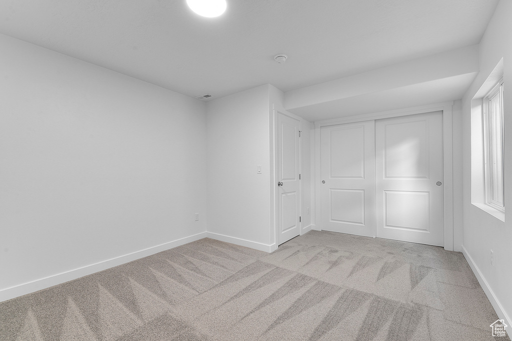 Unfurnished bedroom featuring carpet, baseboards, and a closet