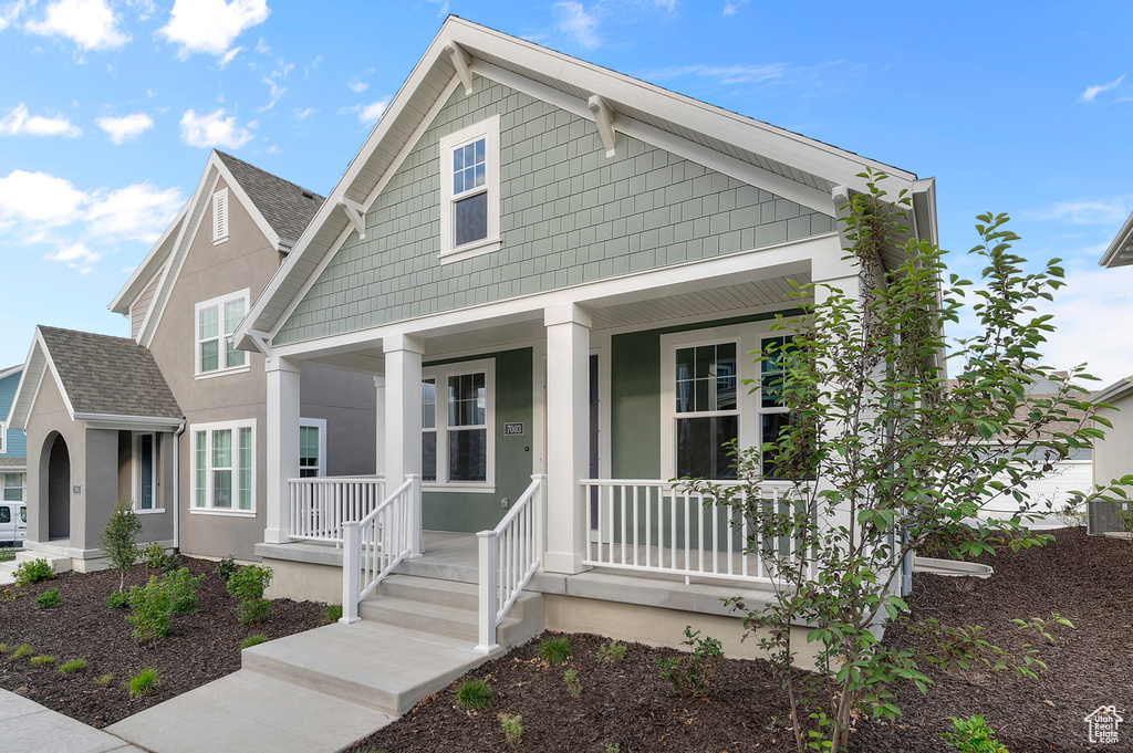 View of front of house with a porch and a shingled roof