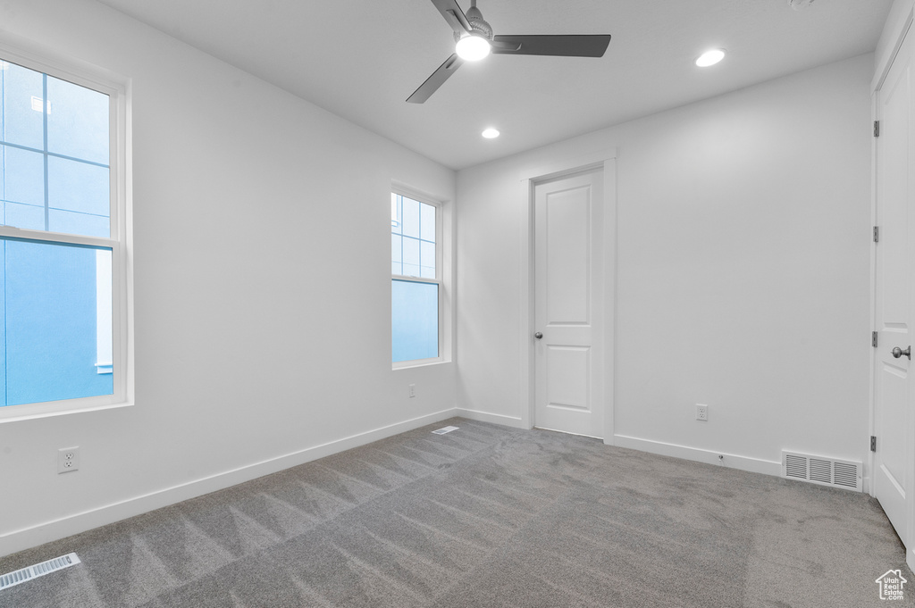 Carpeted empty room with ceiling fan, recessed lighting, and baseboards