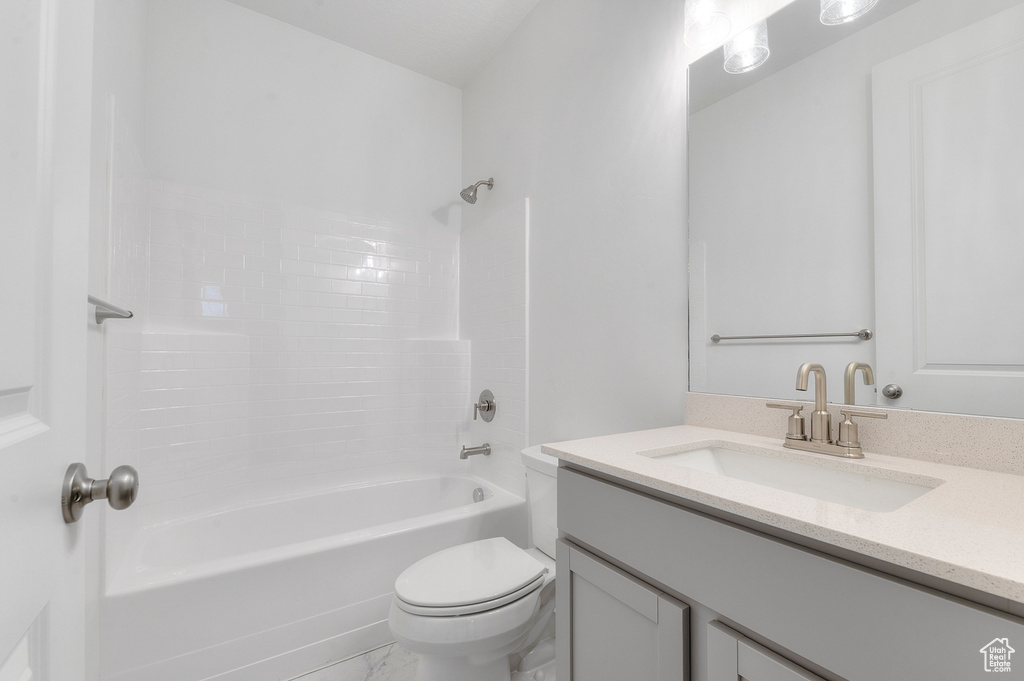 Full bathroom with toilet, vanity, shower / tub combination, and marble look tile flooring