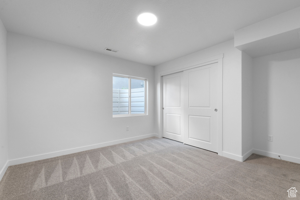 Unfurnished bedroom with carpet floors, baseboards, and a closet