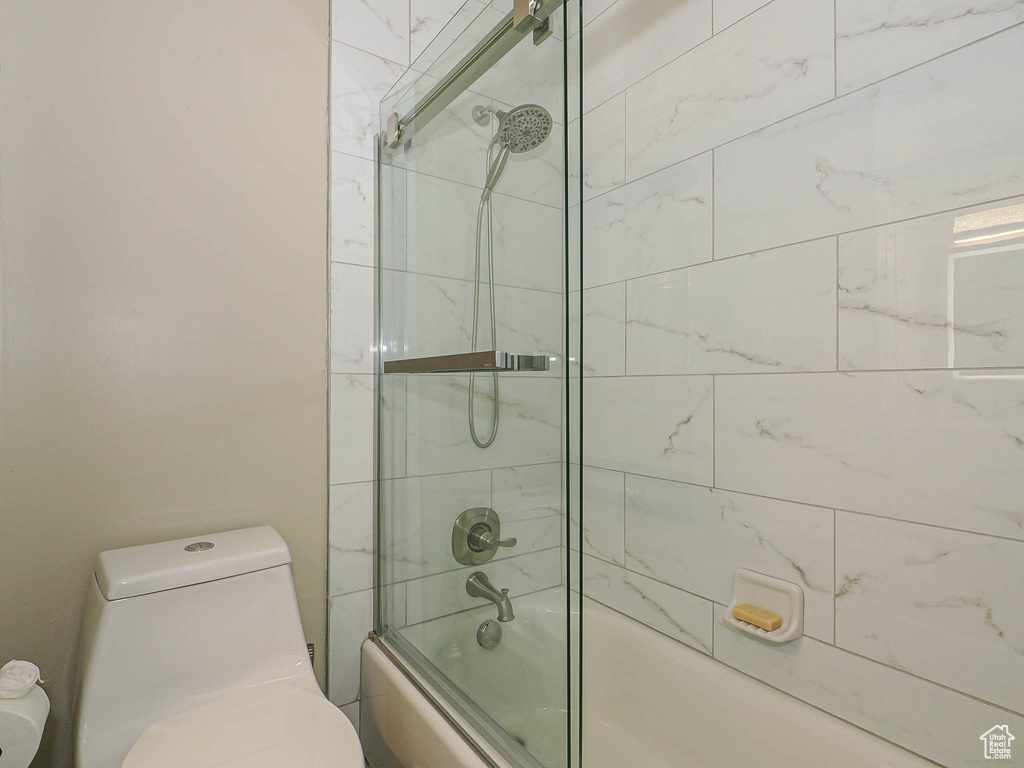 Bathroom featuring toilet and enclosed tub / shower combo