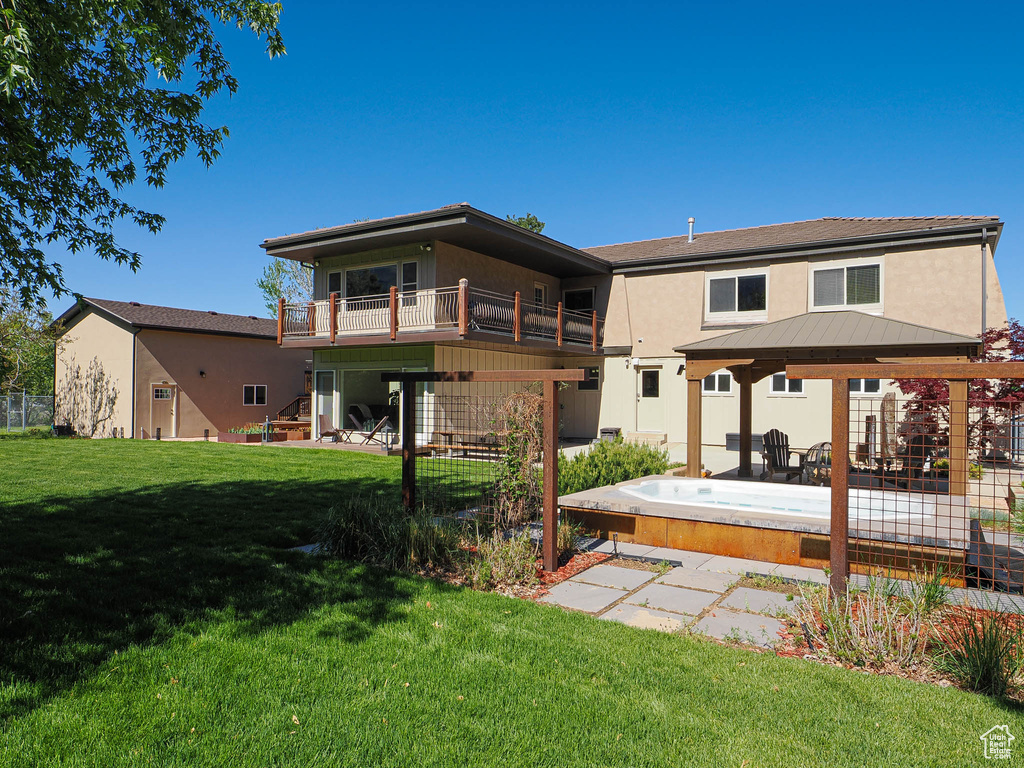 Back of house featuring a gazebo, a lawn, stucco siding, and stairway