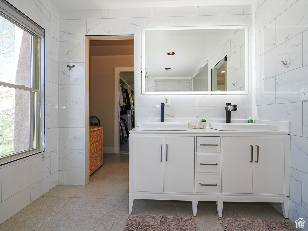 Bathroom featuring double vanity and a walk in closet