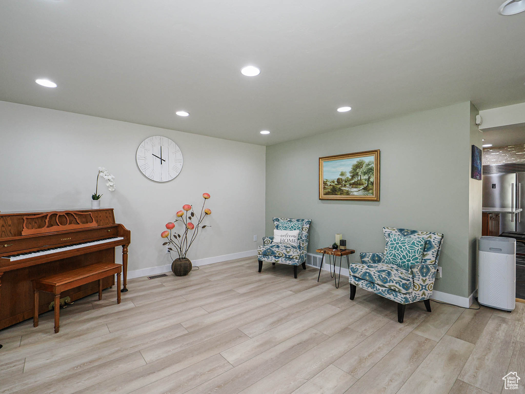 Living area featuring light wood-style flooring, baseboards, and recessed lighting