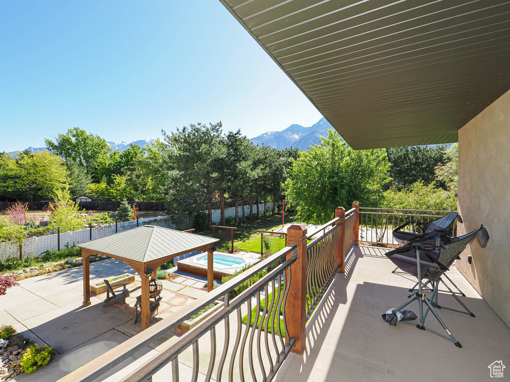 Balcony featuring a jacuzzi, a mountain view, and a patio area
