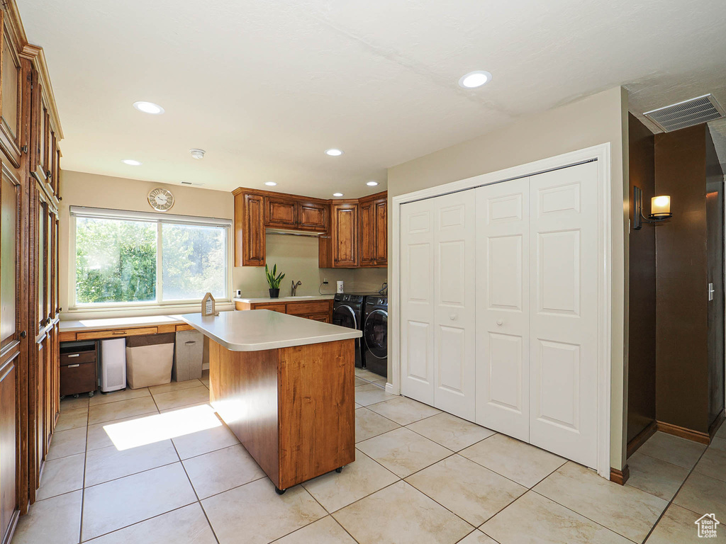 Kitchen featuring washing machine and dryer, light countertops, a sink, recessed lighting, and light tile patterned flooring