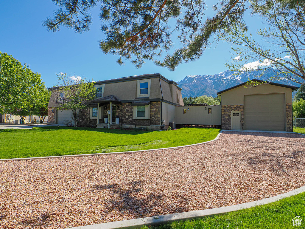 View of front of property with gravel driveway, a front yard, stucco siding, and cooling unit