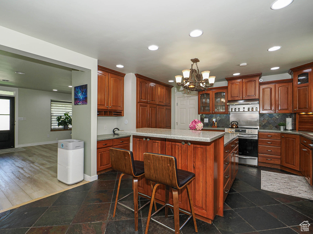 Kitchen with electric stove, glass insert cabinets, recessed lighting, baseboards, and a chandelier