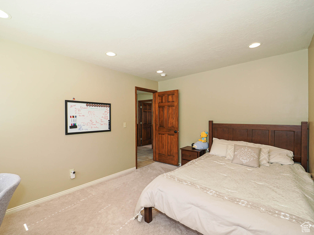 Bedroom with light carpet, recessed lighting, and baseboards