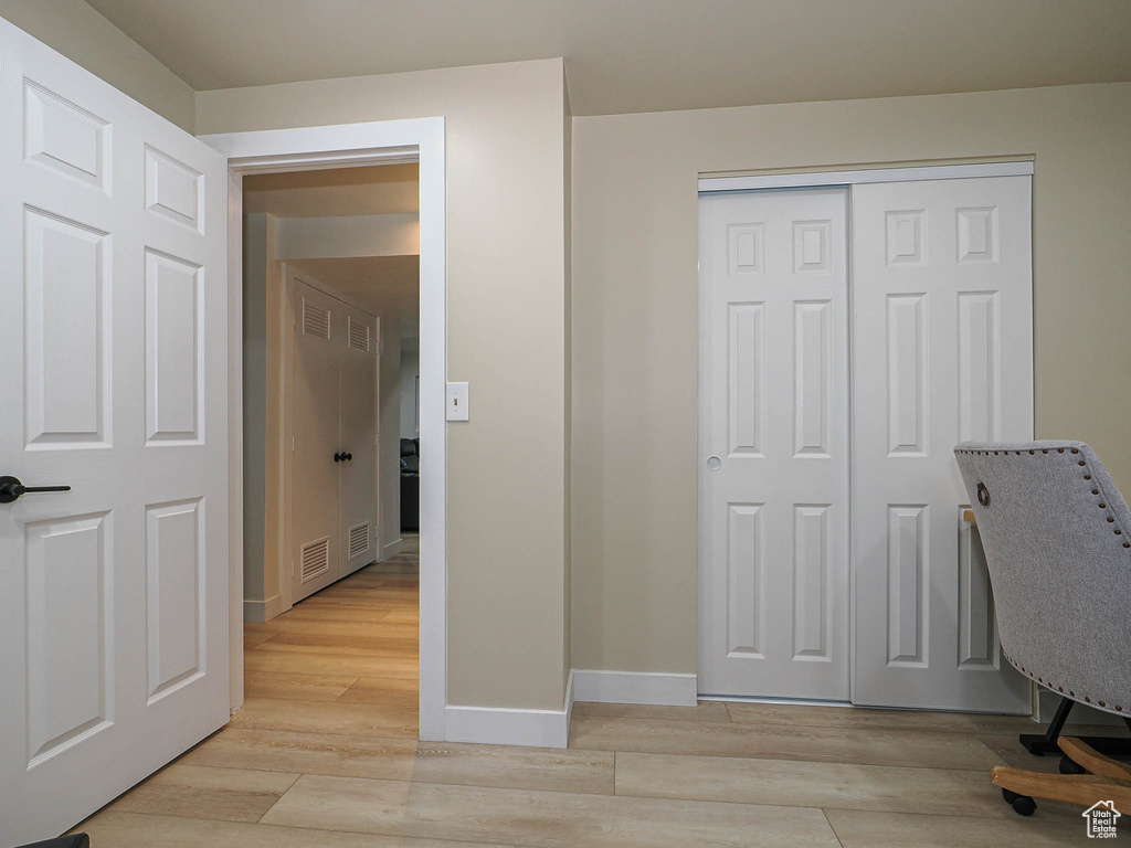 Unfurnished office with baseboards and light wood-style floors