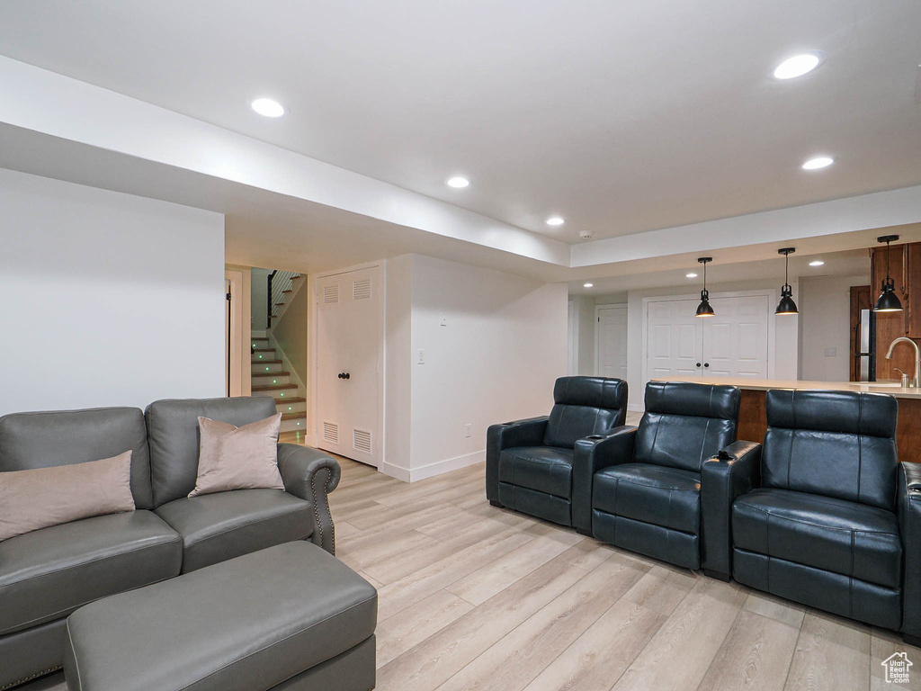 Living area with light wood-style flooring, stairway, recessed lighting, baseboards, and bar