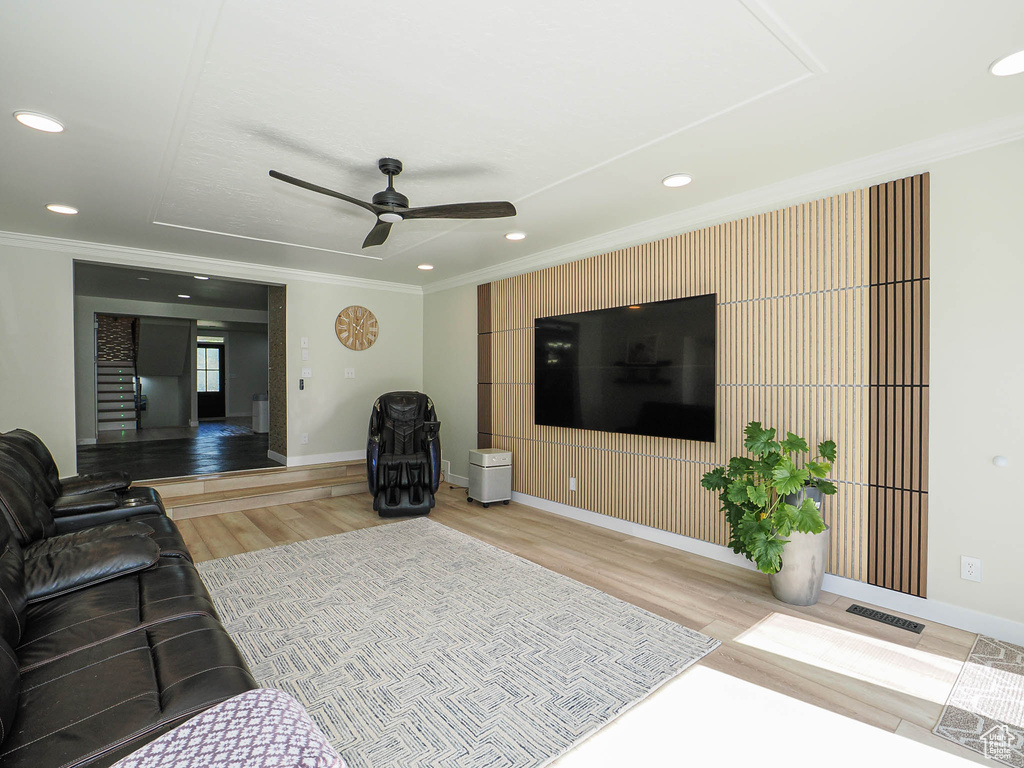 Living area featuring light wood-style floors, ceiling fan, crown molding, baseboards, and recessed lighting