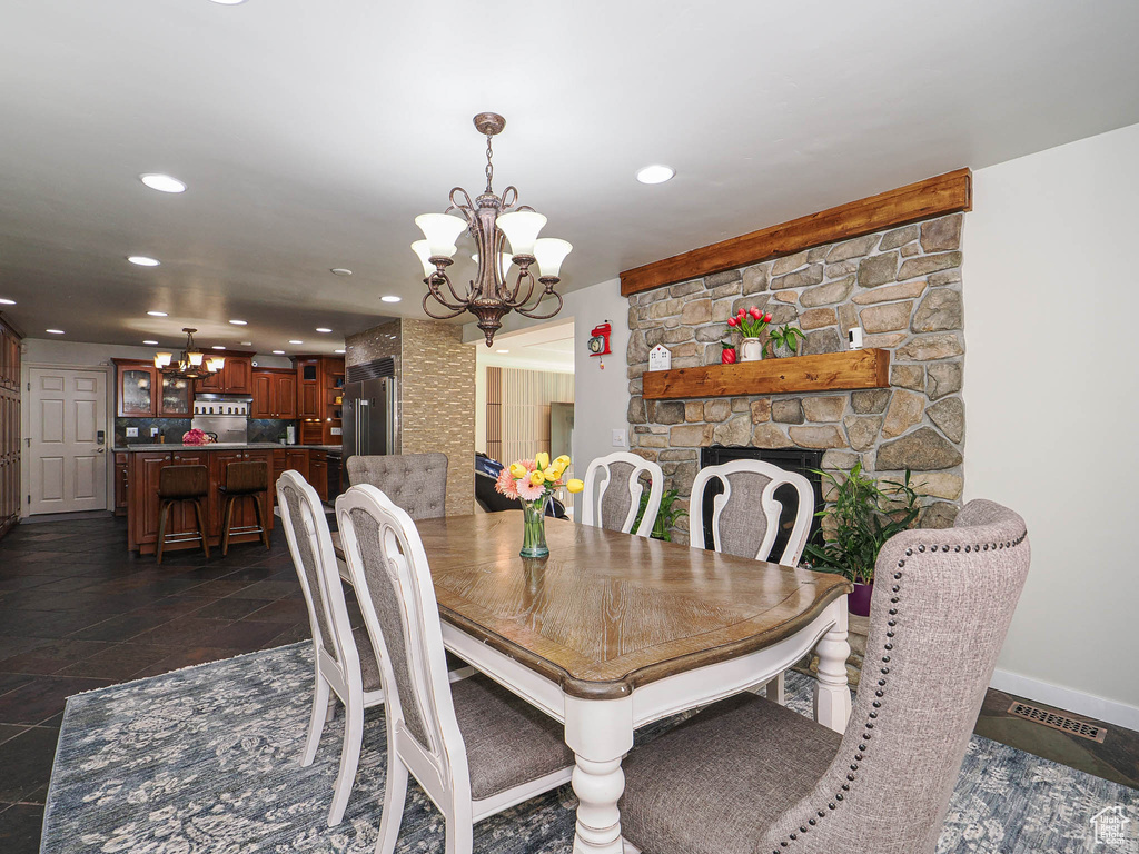 Dining room with a chandelier, recessed lighting, baseboards, and a fireplace