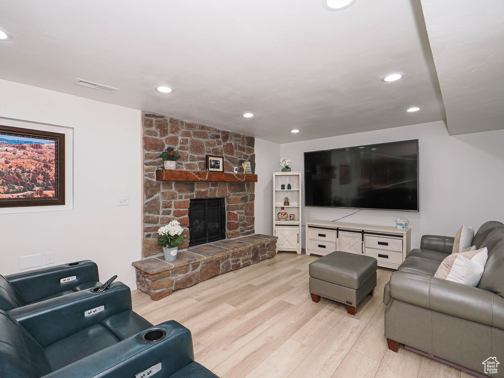 Living area with light wood finished floors, a fireplace, and recessed lighting