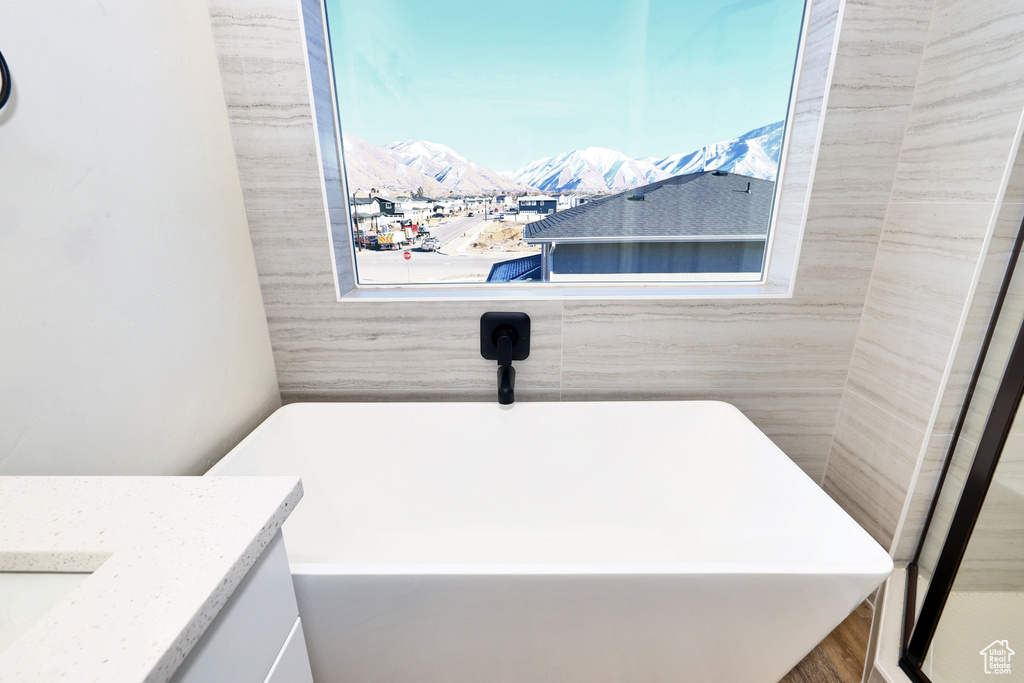 Full bath with a mountain view, a freestanding tub, and vanity