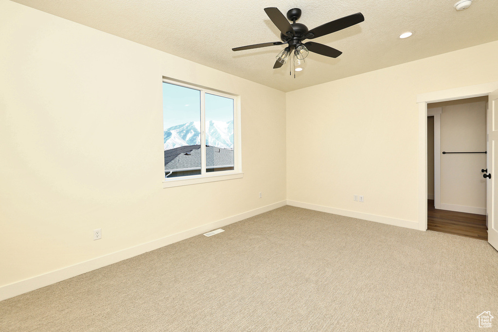 Unfurnished bedroom featuring light colored carpet, recessed lighting, baseboards, a ceiling fan, and a textured ceiling