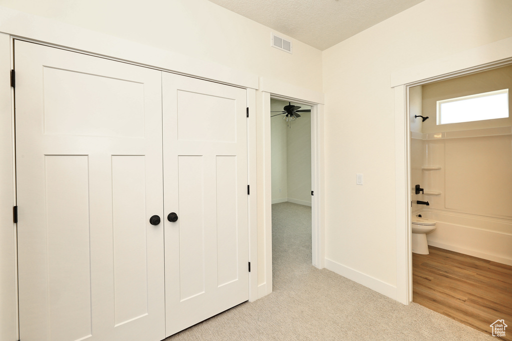 Unfurnished bedroom featuring light colored carpet, baseboards, and ensuite bath