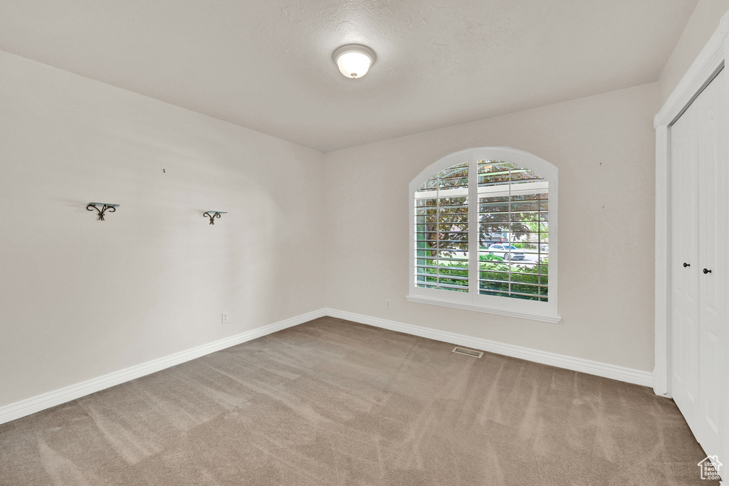 Carpeted empty room featuring baseboards