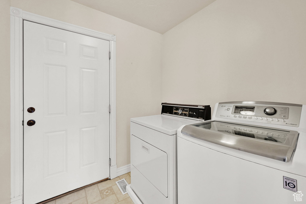 Laundry area with independent washer and dryer and baseboards