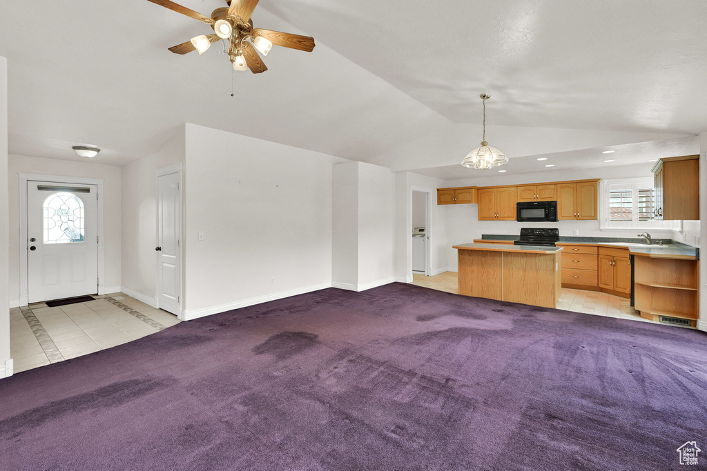 Unfurnished living room featuring lofted ceiling, a ceiling fan, baseboards, plenty of natural light, and a sink