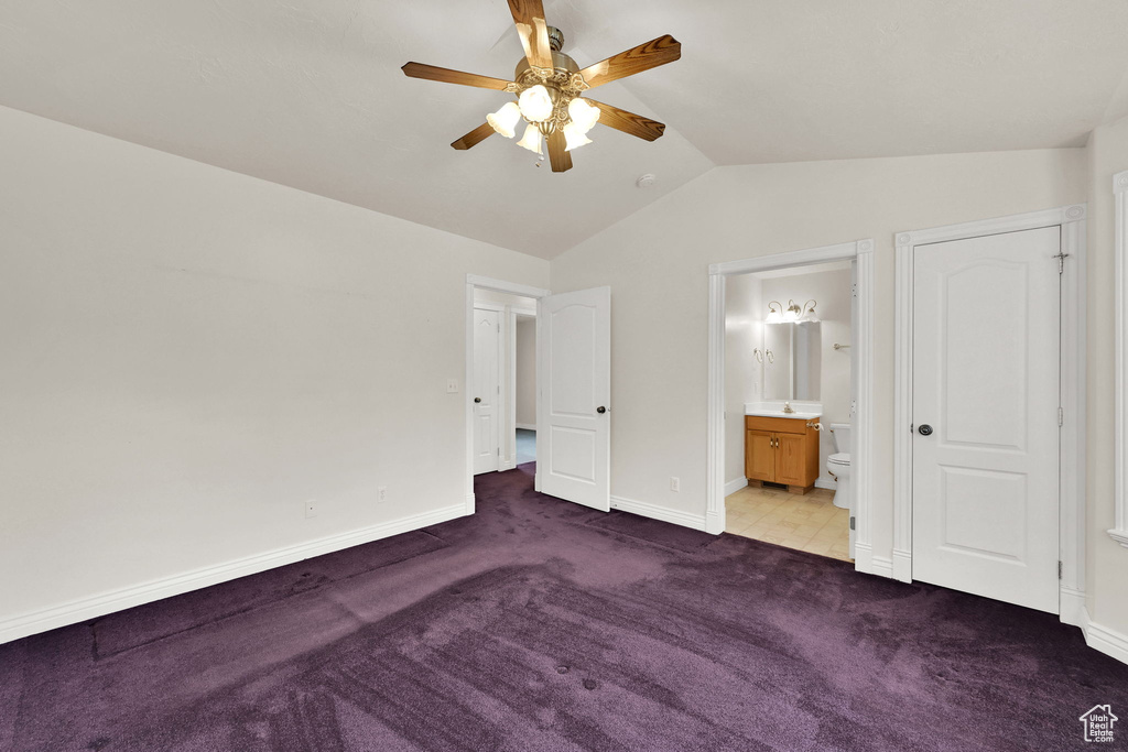 Unfurnished bedroom with carpet flooring, vaulted ceiling, baseboards, connected bathroom, and a sink