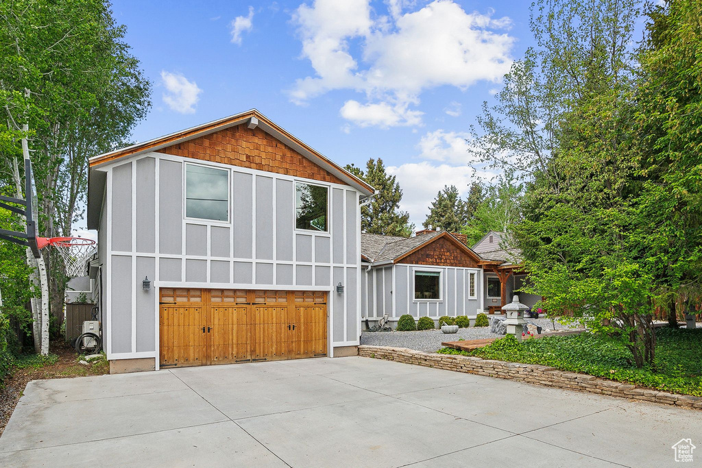View of front of property with a garage, concrete driveway, and board and batten siding