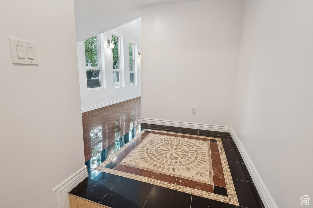 Hall featuring inlaid floor details and baseboards