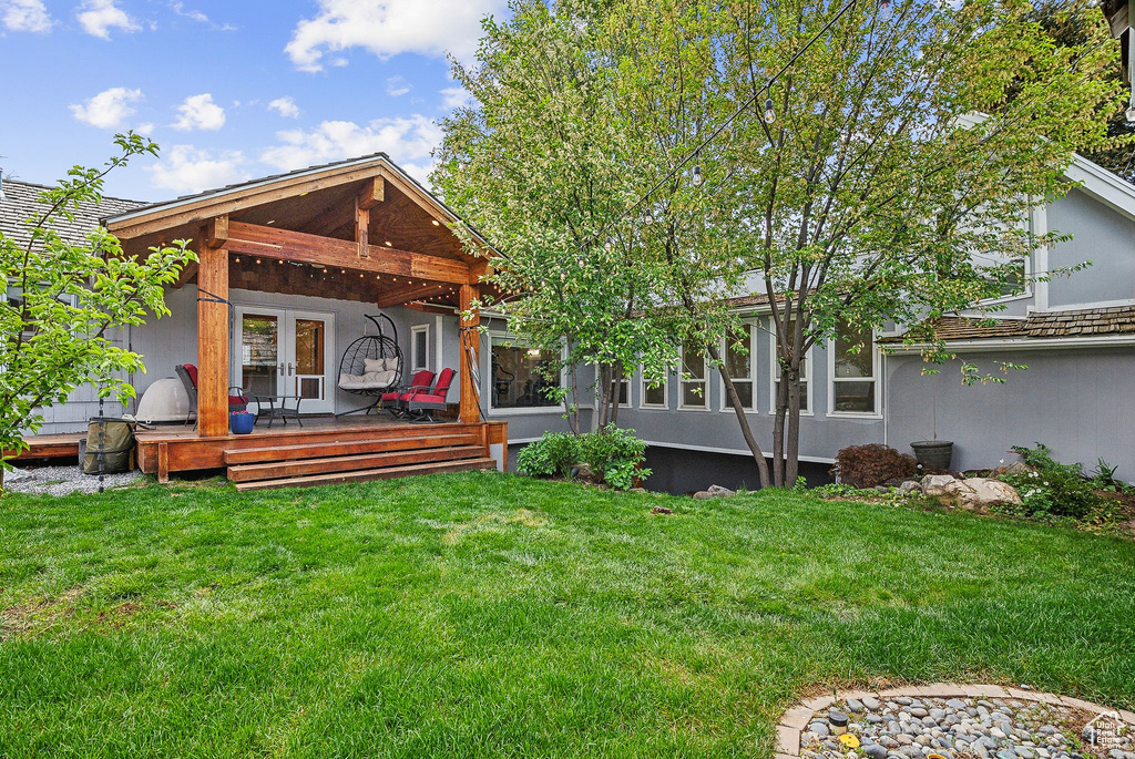 Rear view of property featuring a yard and a deck