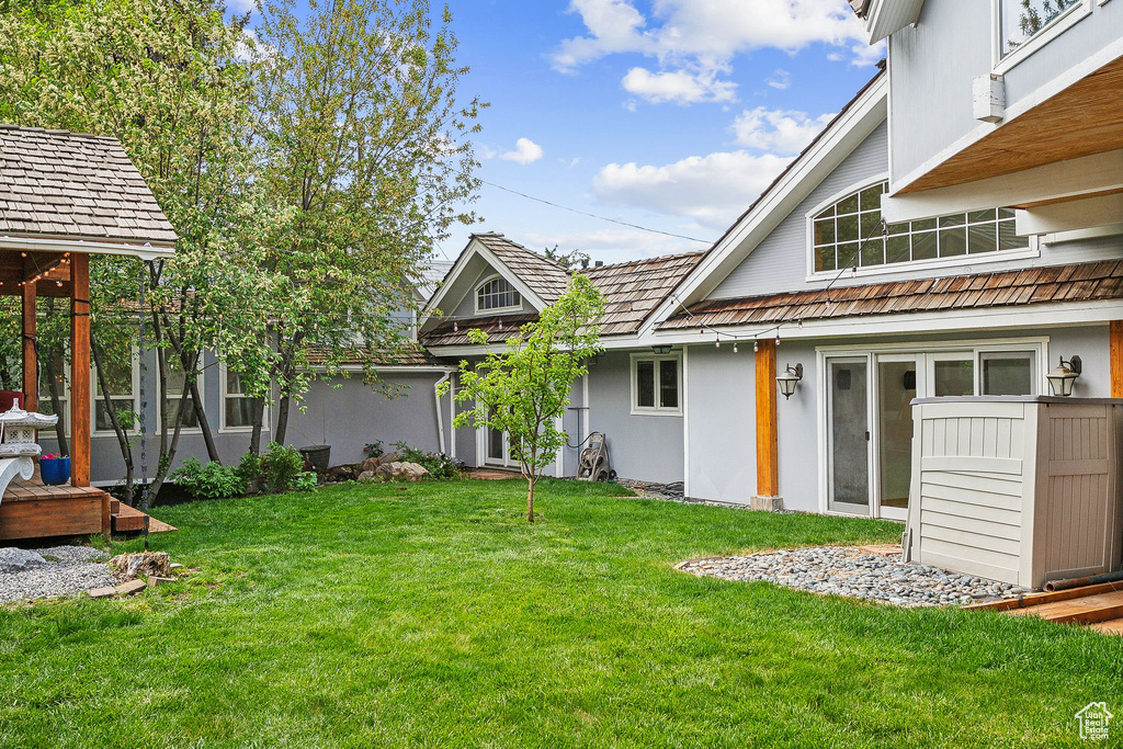 Rear view of property with a yard and stucco siding