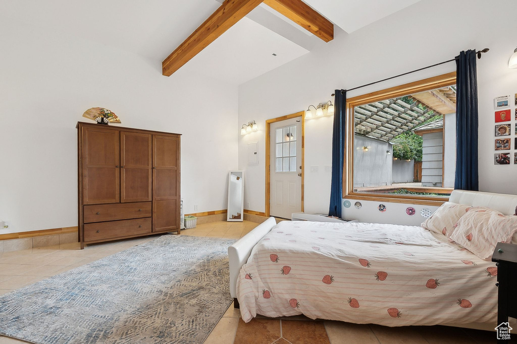 Bedroom with light tile patterned floors, beamed ceiling, and baseboards