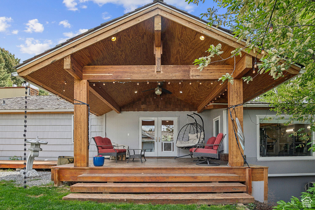 Rear view of property with french doors, a wooden deck, and ceiling fan