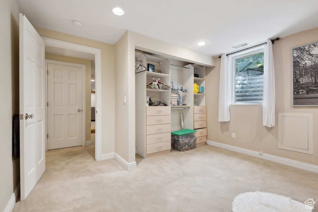 Bedroom with light colored carpet, baseboards, recessed lighting, and a closet