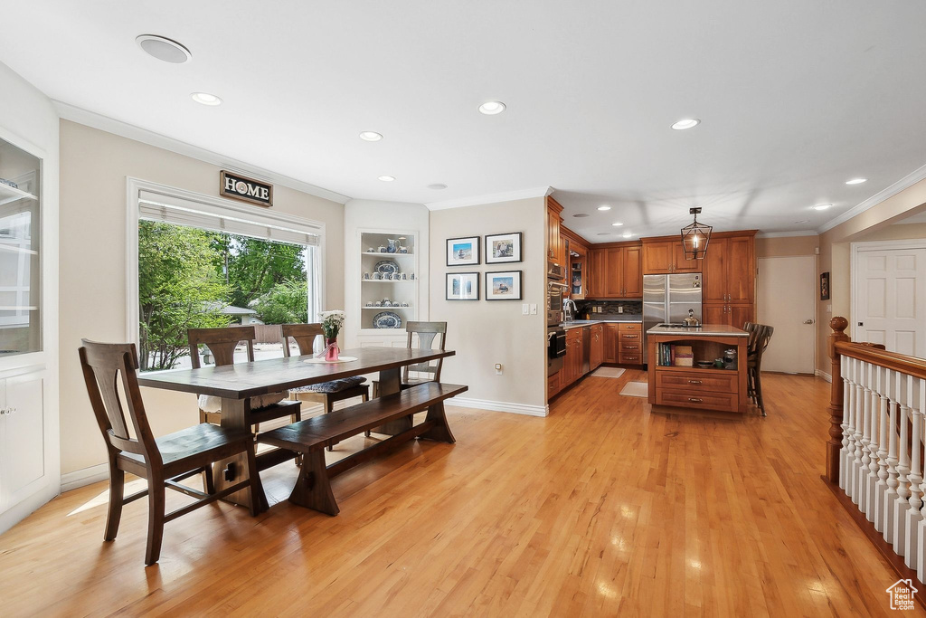 Dining room with recessed lighting, ornamental molding, light wood-style flooring, built in features, and baseboards