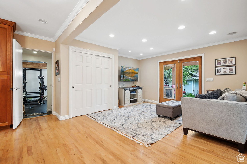 Living area featuring baseboards, light wood-style floors, crown molding, and recessed lighting