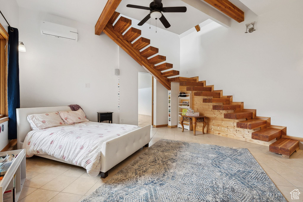 Tiled bedroom featuring a wall unit AC, beamed ceiling, and a ceiling fan