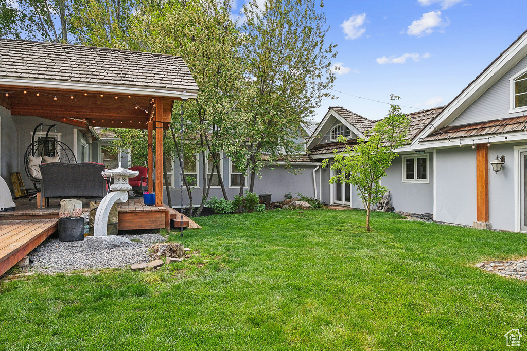 View of green lawn with a wooden deck