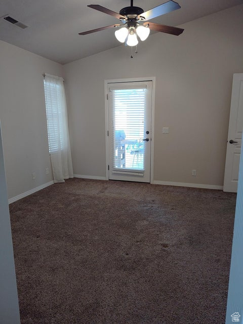 Unfurnished room with ceiling fan, lofted ceiling, carpet floors, and baseboards