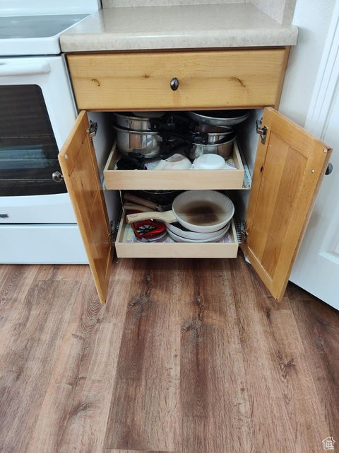 Kitchen view of white range with electric cooktop and wood finished floors