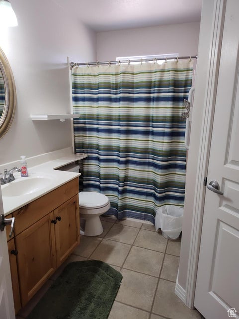 Full bathroom featuring toilet, tile patterned flooring, vanity, and a shower with shower curtain