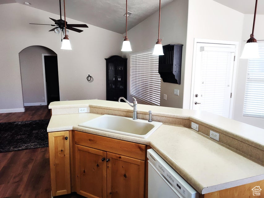 Kitchen with dishwasher, a sink, vaulted ceiling, dark wood finished floors, and ceiling fan