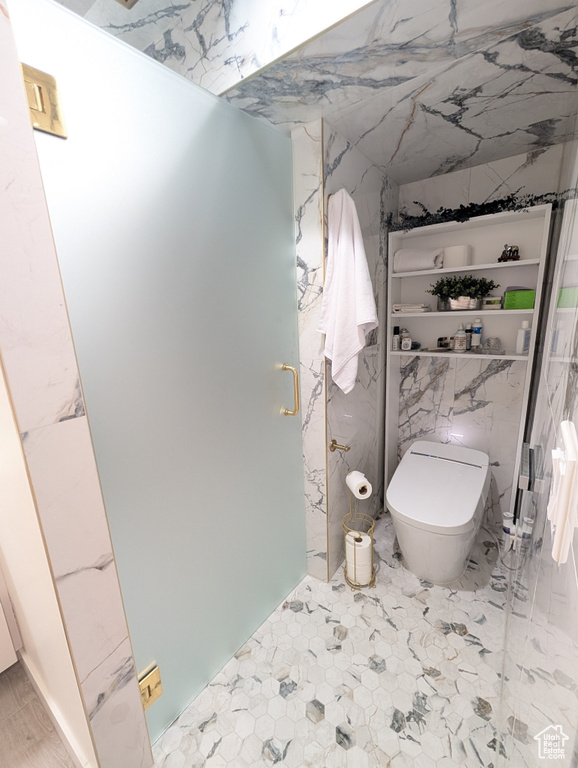 Full bathroom featuring a stall shower and toilet