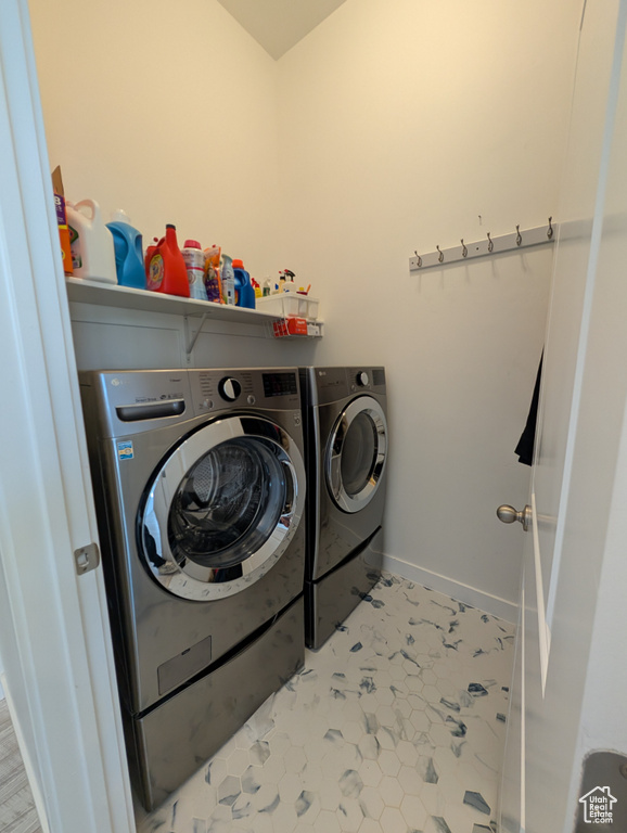 Laundry area featuring separate washer and dryer and baseboards
