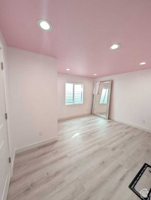 Spare room featuring light wood-type flooring, recessed lighting, and baseboards