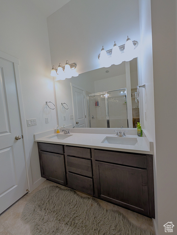 Bathroom featuring a shower stall and double vanity