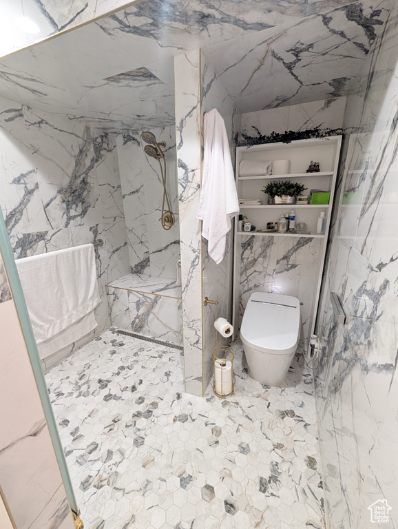 Full bathroom featuring a marble finish shower and toilet