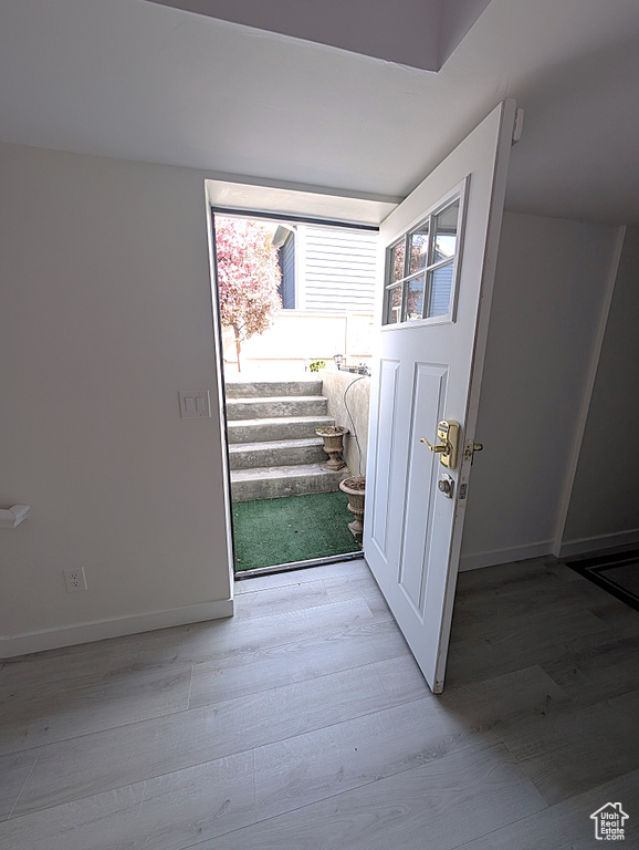 Doorway featuring light wood-style floors and baseboards