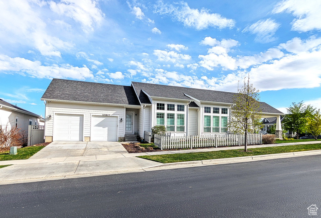 Single story home featuring a garage and driveway